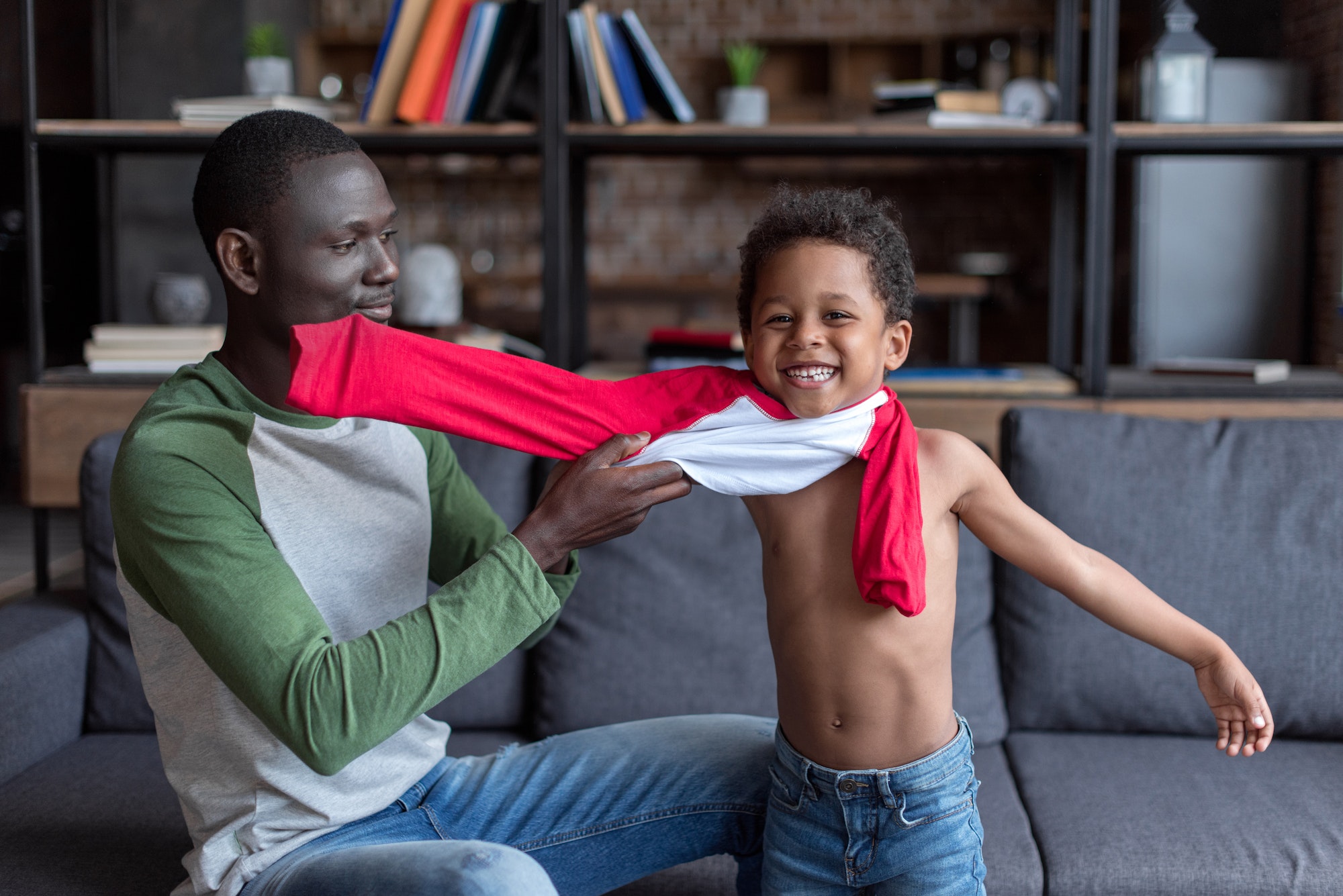 loving african-american father dressing up his smiling son